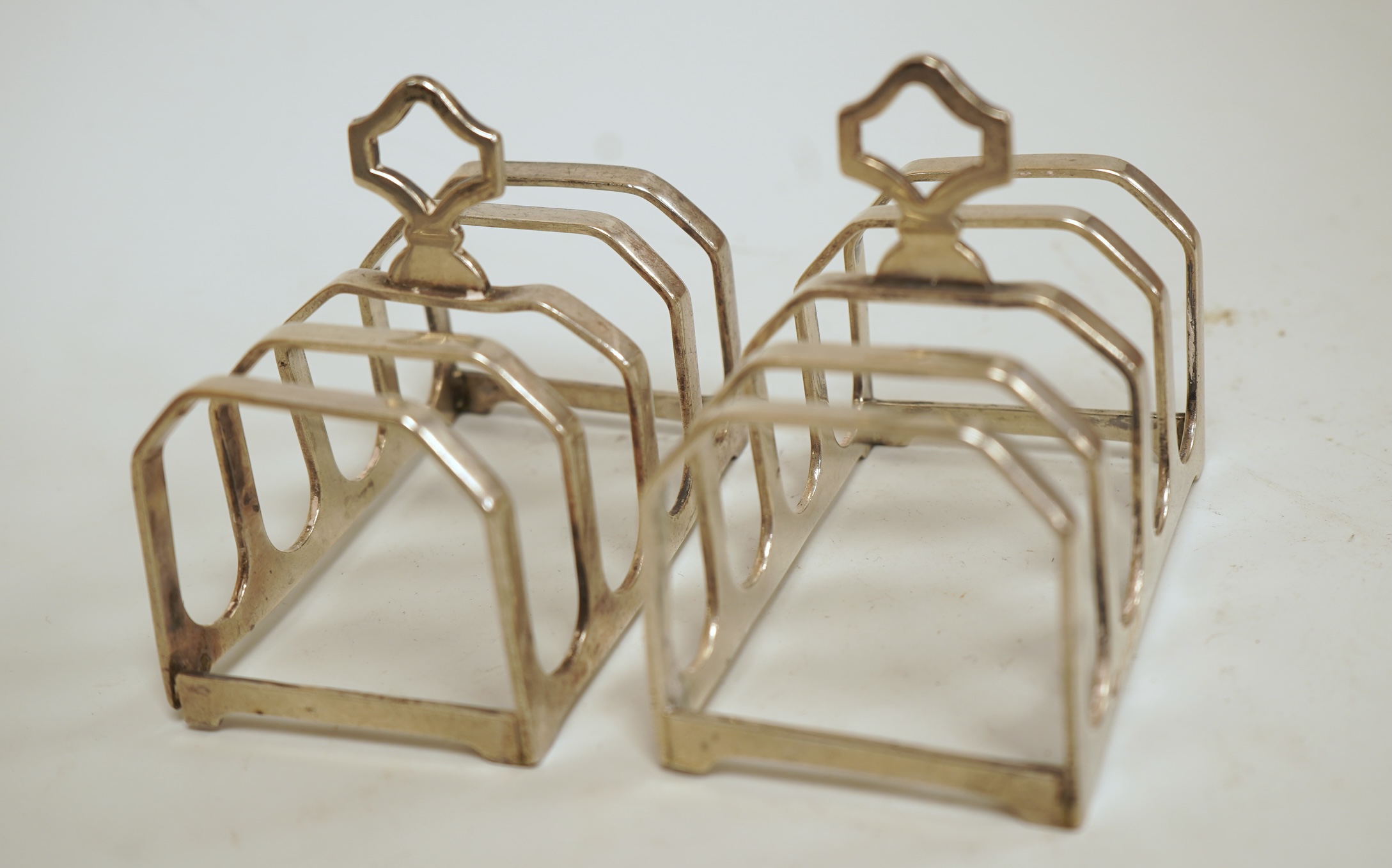 A pair of small George V silver five bar toast racks, Adie Brothers, Birmingham, 1930, length 76mm, together with six assorted silver condiments.